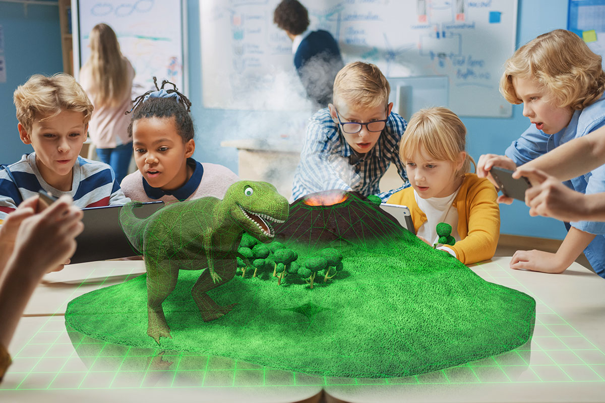children using laptops sit at a table with a digital dinosaur hologram in the middle.