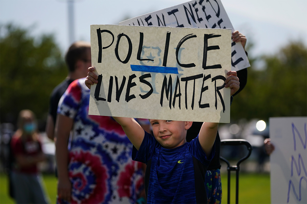 A boy holds a sign reading Police Lives Matter.