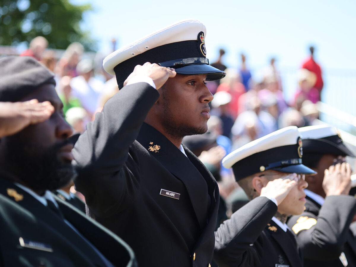Soldiers in uniform saluting.