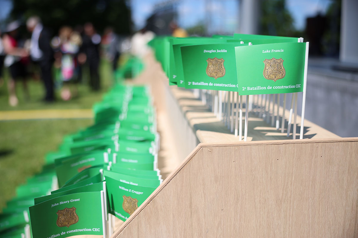 A series of small green flags with an emblem, names and No.2 Construction Battalion written on them.