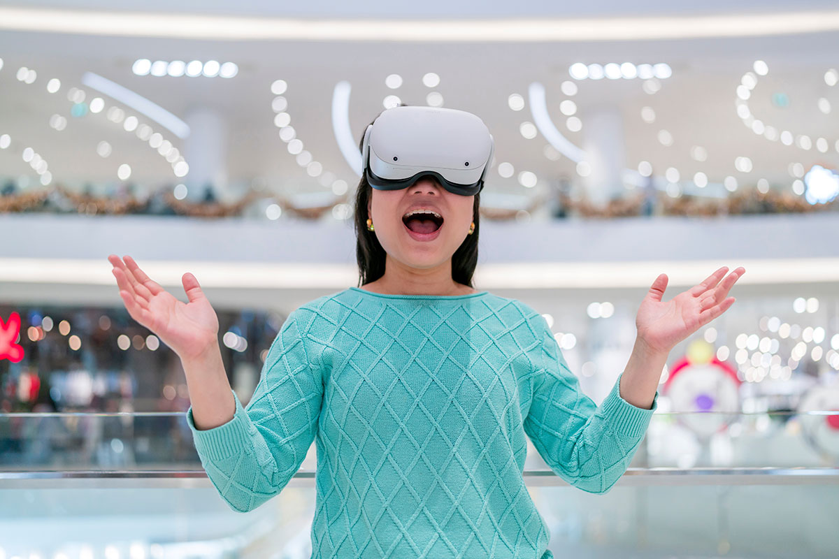 A woman wearing a VR headset standing in a shopping mall.