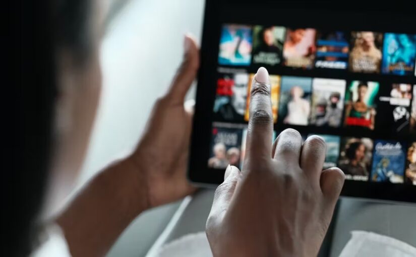 A person swiping through a video streaming service selection screen on a tablet