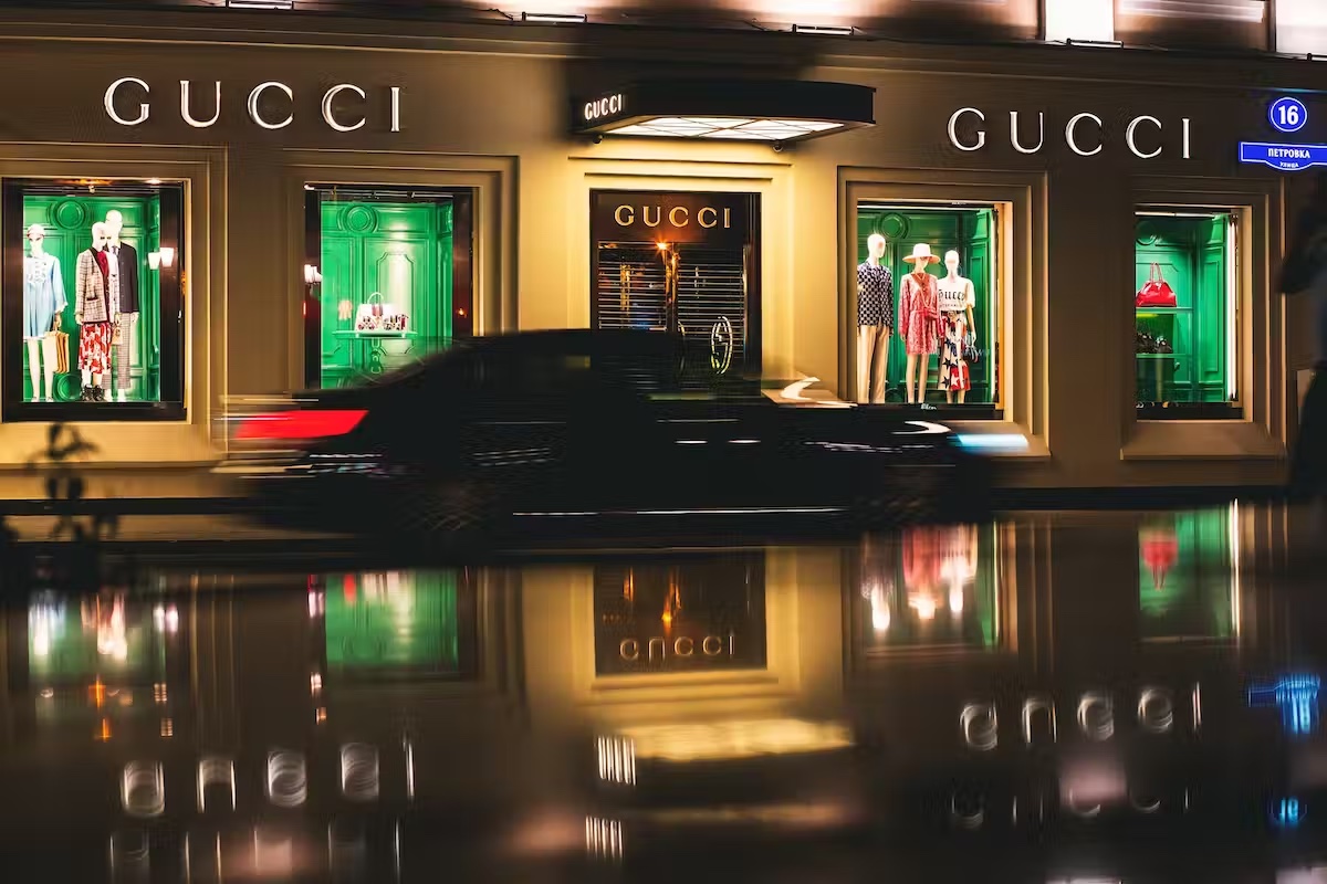 A car speeds past a Gucci store at night.