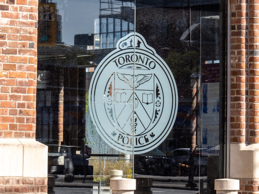 A logo of the toronto police service on a glass door.