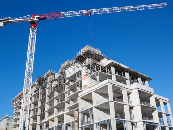 A crane stands over a building that is under construction