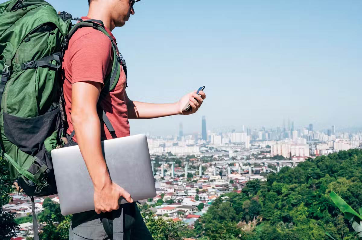 A backpacker carrying a laptop and smartphone.