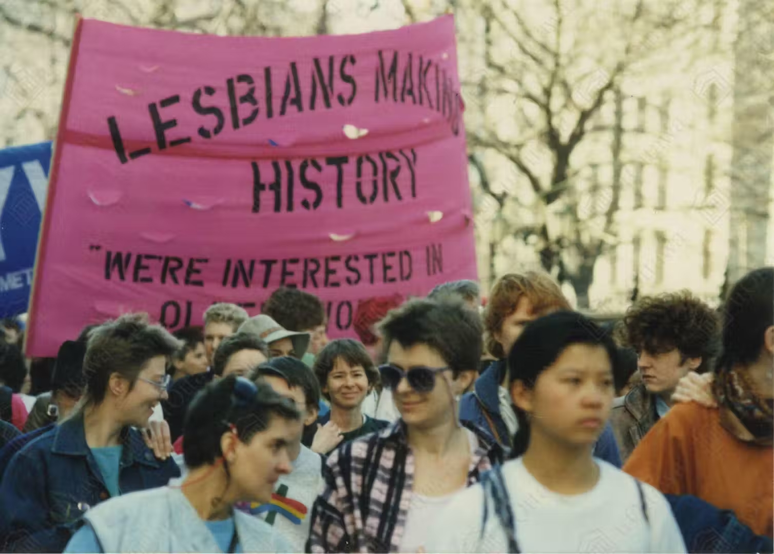 People at a demonstration carry a banner reading: lesbians making history, we're interested in older women."